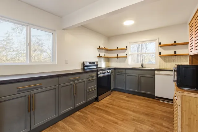 a kitchen with a sink window and cabinets