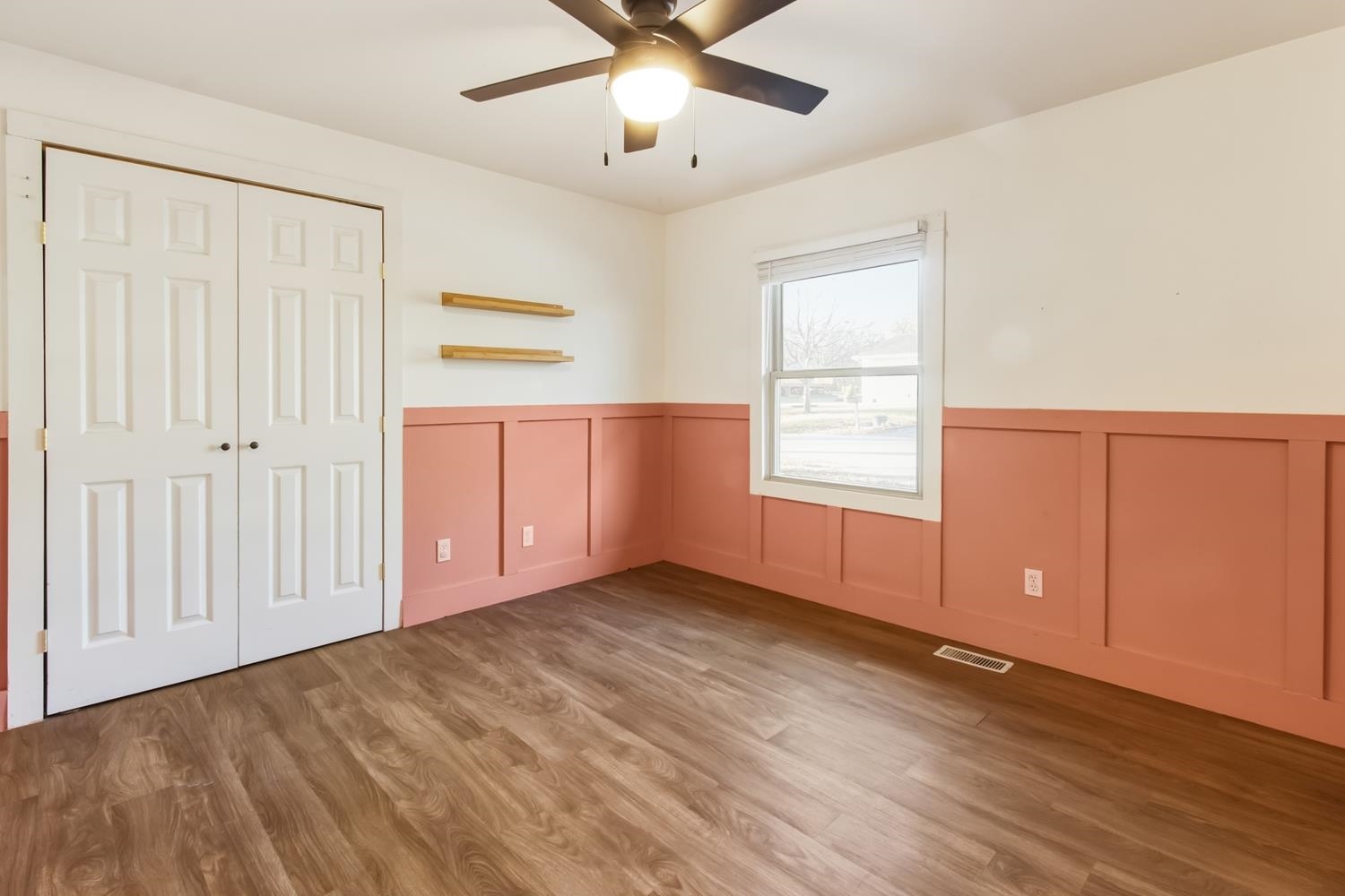 506 Eells Avenue Dixon, IL 61021 - Photo 8 of 19 an empty room with wooden floor chandelier fan and windows