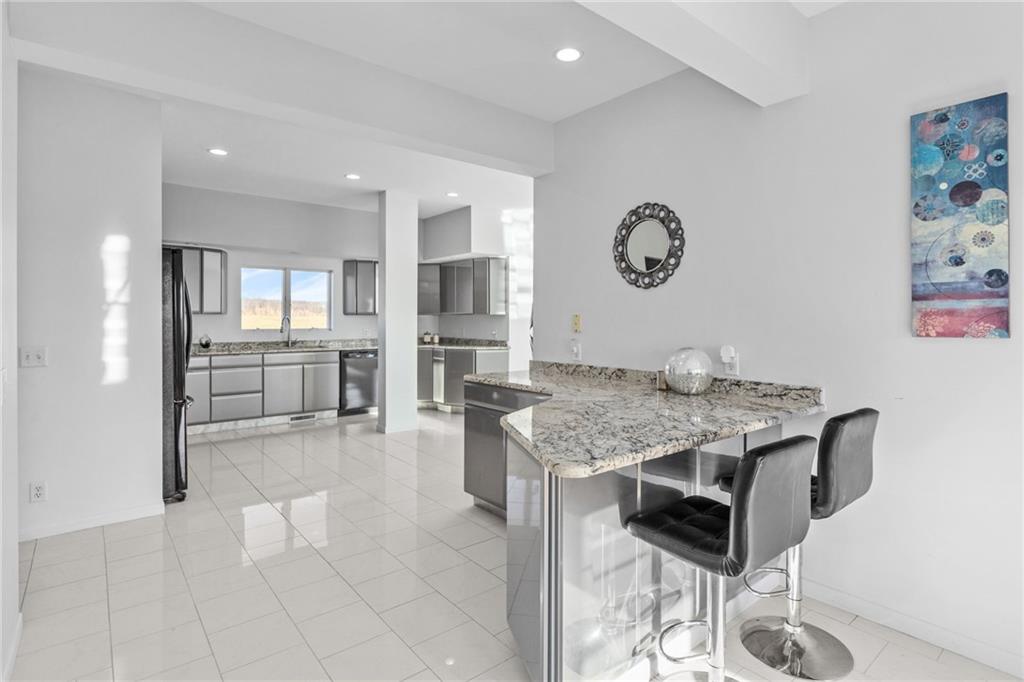 427 Jones Road Harrisville, PA 16038 - Photo 14 of 29 a kitchen with stainless steel appliances granite countertop a stove top oven a sink dishwasher and a refrigerator with wooden floor