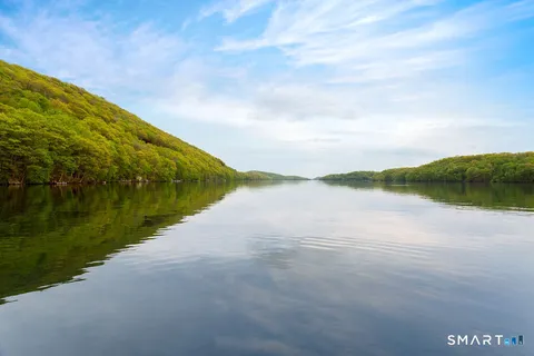 a view of a lake with chairs and a table