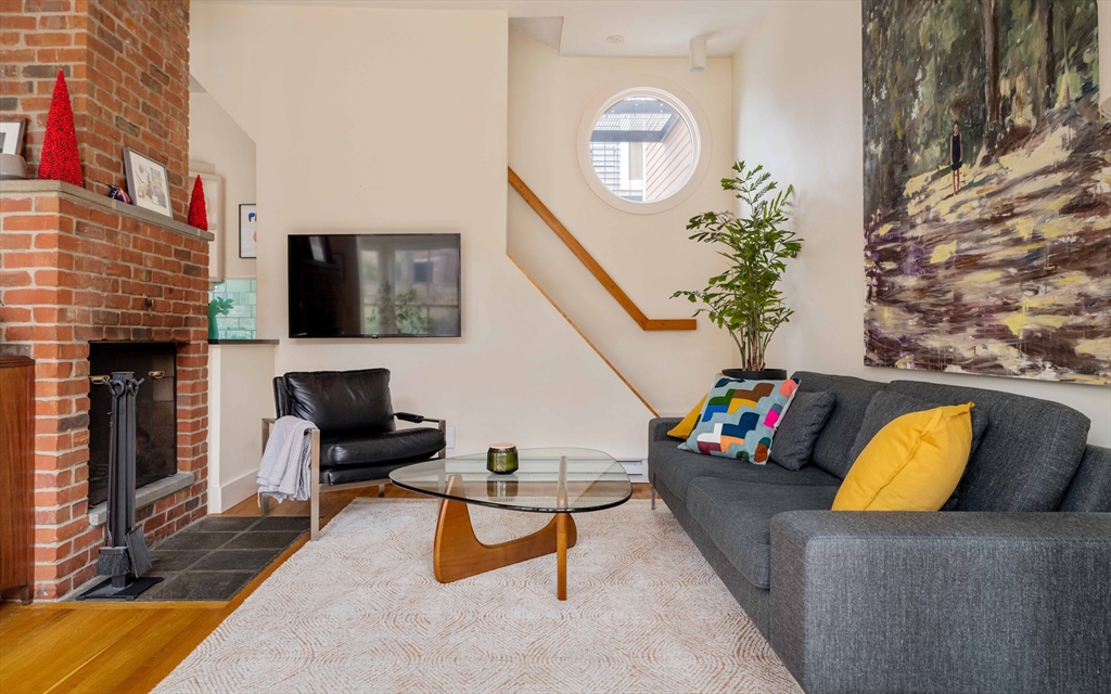 61 Dana Street, Unit 4 Cambridge, MA 02138 - Photo 12 of 25 a living room with furniture fireplace and a flat screen tv