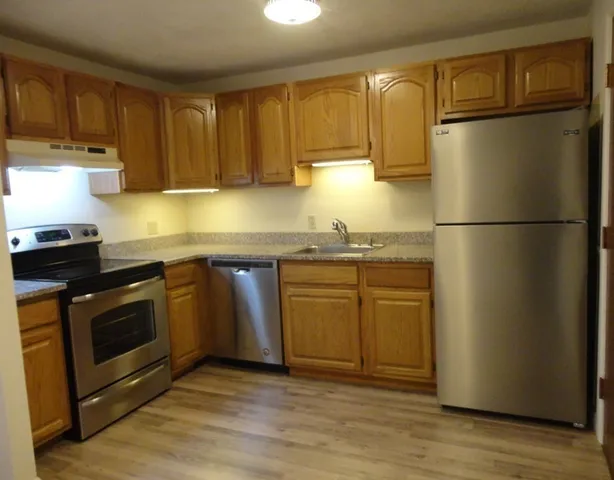 a kitchen with stainless steel appliances granite countertop a refrigerator stove a sink and a granite counter tops