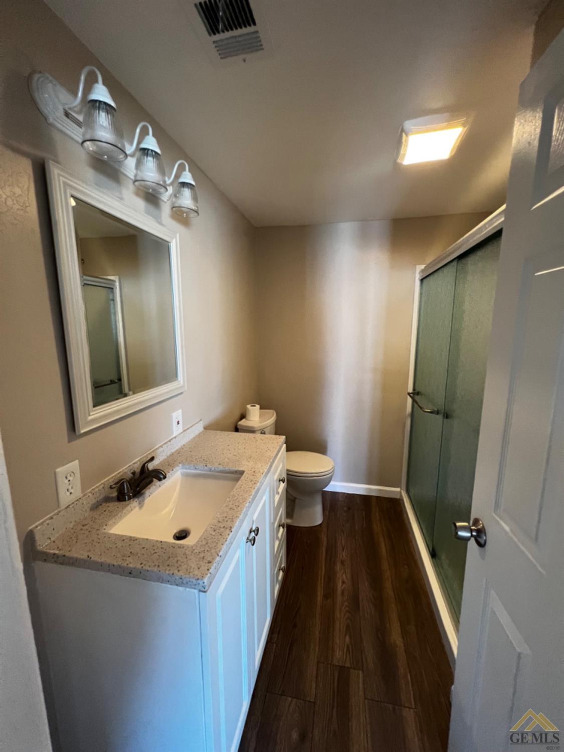 Undisclosed Address Bakersfield, CA 93304 - Photo 5 of 18 a bathroom with a sink and mirror with toilet