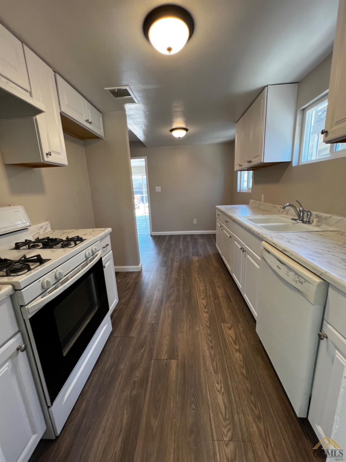 Undisclosed Address Bakersfield, CA 93304 - Photo 10 of 18 a kitchen with a stove and a wooden floor