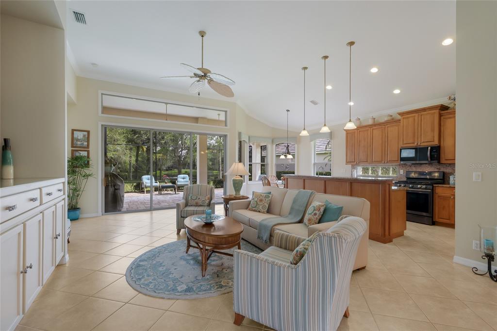 11709 Strandhill Court Lakewood Ranch, FL 34202 - Photo 6 of 51 a living room with furniture kitchen and a chandelier