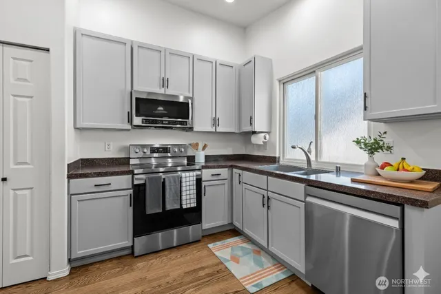 a kitchen with stainless steel appliances granite countertop a stove a sink and a microwave