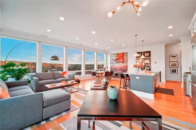 a living room with furniture kitchen view and a large window