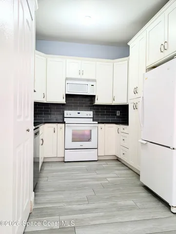 a kitchen with stainless steel appliances a white cabinets and a refrigerator