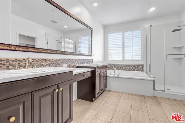 a spacious bathroom with a granite countertop sink a mirror and a bathtub