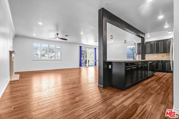 a large kitchen with lots of counter space and wooden floor