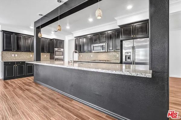 a kitchen with stainless steel appliances granite countertop a refrigerator and a stove