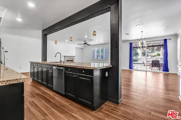 a kitchen with stainless steel appliances granite countertop a stove and a wooden floors