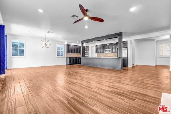 a view of empty room with wooden floor and ceiling fan