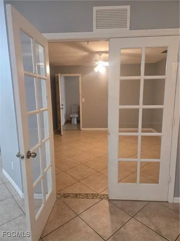 a view of an empty room with cabinet and door