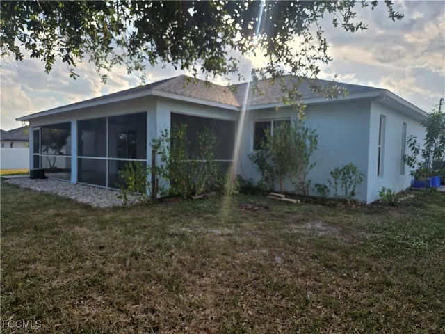 a view of a house with a yard and large tree