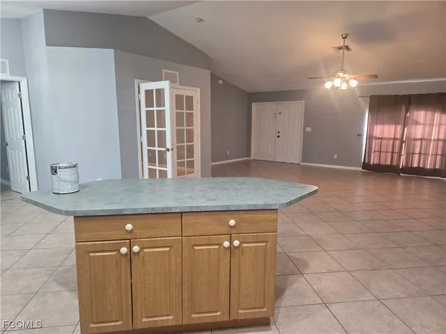 a view of kitchen with granite countertop cabinets and chandelier