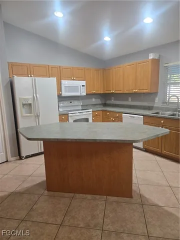 a kitchen with stainless steel appliances granite countertop a refrigerator a sink and a stove