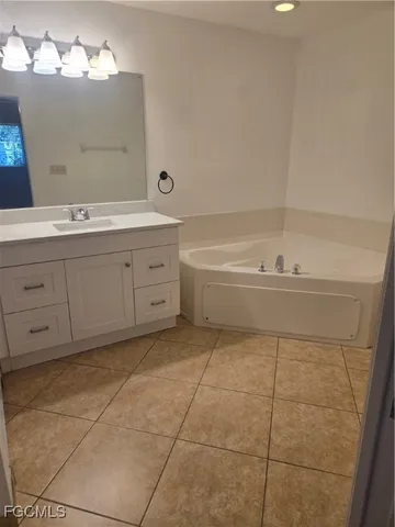 a spacious bathroom with a bathtub sink vanity and mirror