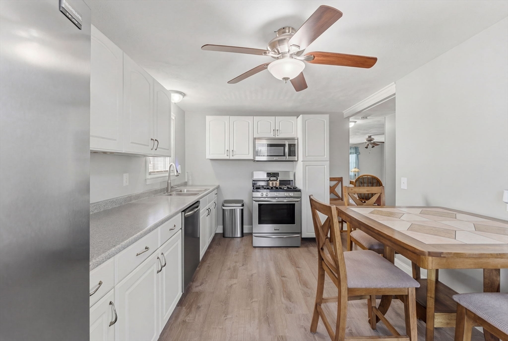 76 Lake Street Pawtucket, RI 02860 - Photo 7 of 18 a kitchen with stainless steel appliances granite countertop a white cabinets and wooden floor