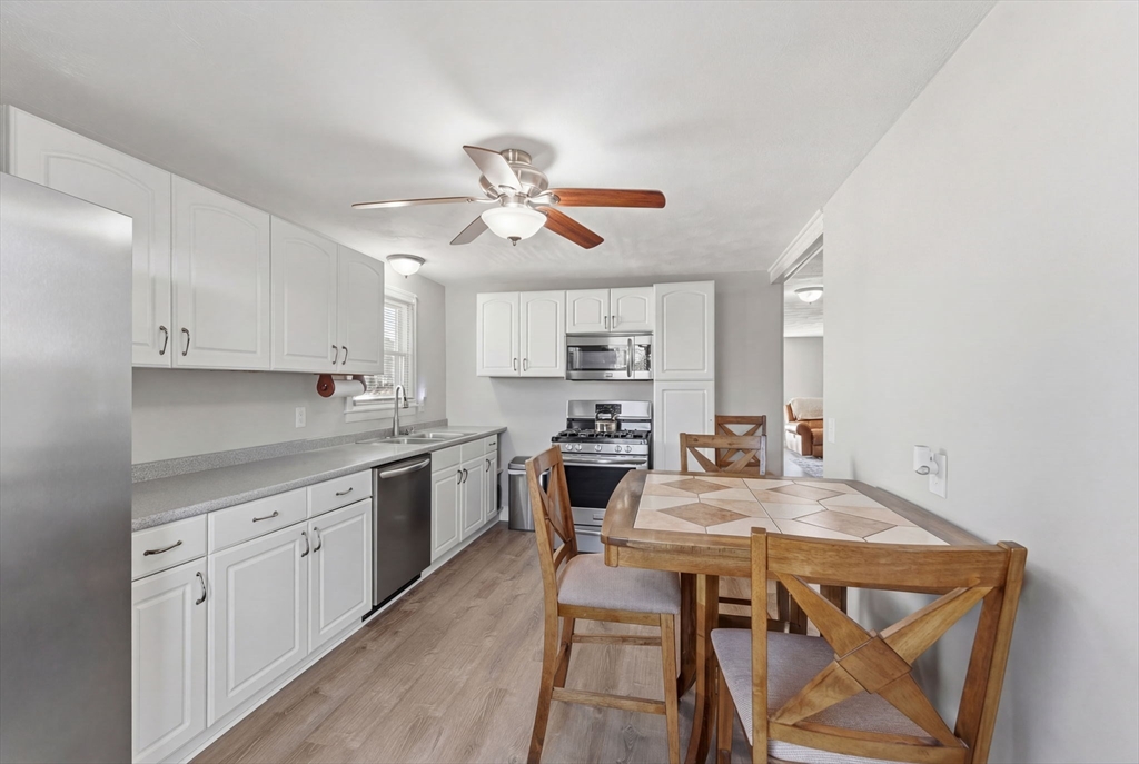 76 Lake Street Pawtucket, RI 02860 - Photo 8 of 18 a kitchen with stainless steel appliances granite countertop a stove a sink dishwasher and a refrigerator with wooden floor