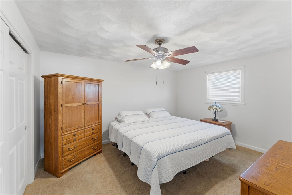 76 Lake Street Pawtucket, RI 02860 - Photo 9 of 18 a bedroom with a large bed and a chandelier