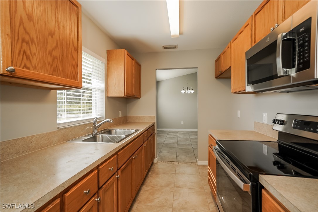 16981 First Street Alva, FL 33920 - Photo 8 of 16 a kitchen with stainless steel appliances granite countertop a sink stove and microwave