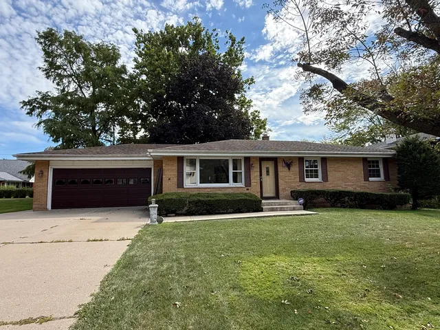 a front view of a house with a yard and trees