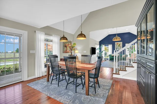 a kitchen with stainless steel appliances a dining table chairs refrigerator and microwave