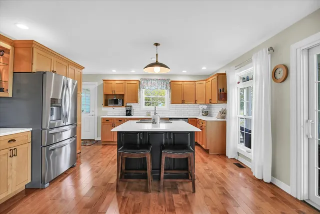 a kitchen with stainless steel appliances granite countertop a sink a stove and a refrigerator