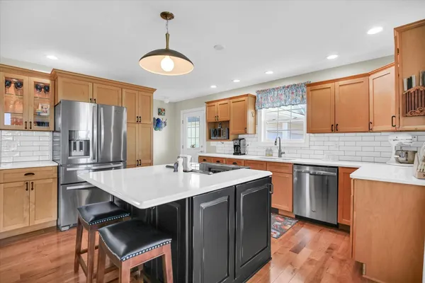 a kitchen with kitchen island a large window and stainless steel appliances