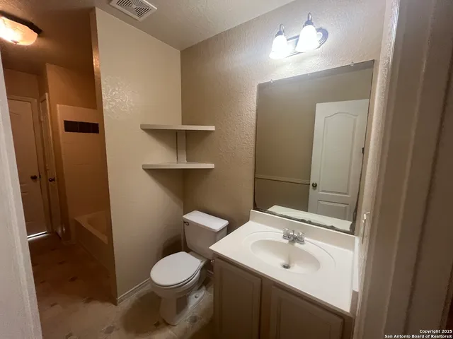 a bathroom with a toilet sink and mirror