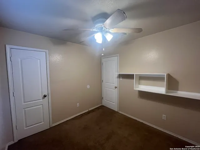a view of a livingroom with a ceiling fan and window