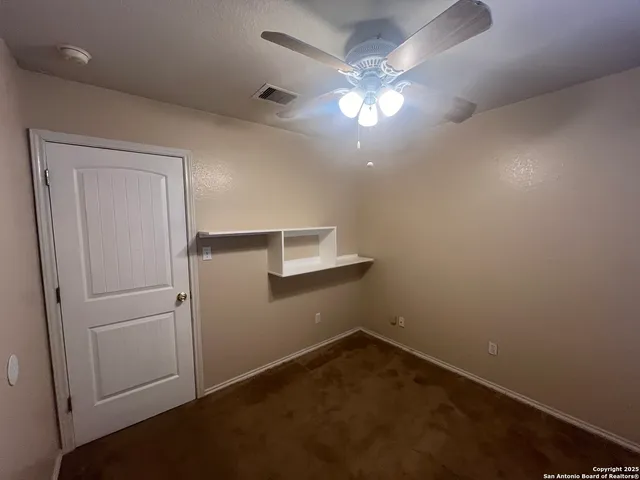 an empty room with a empty space and a ceiling fan