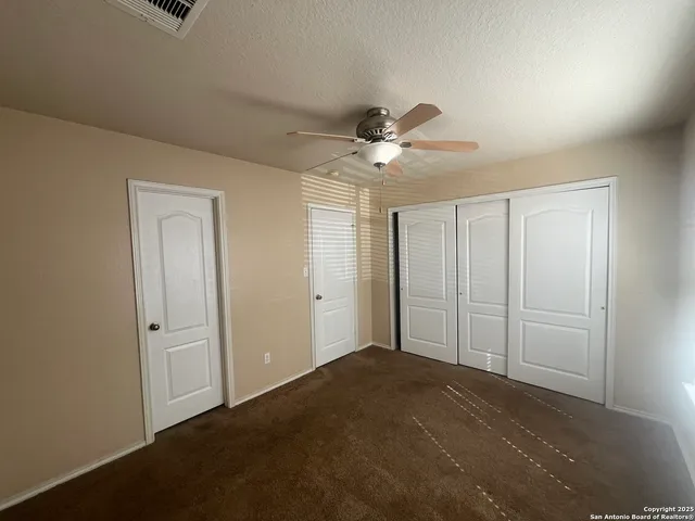 a view of a livingroom with a ceiling fan and closet area