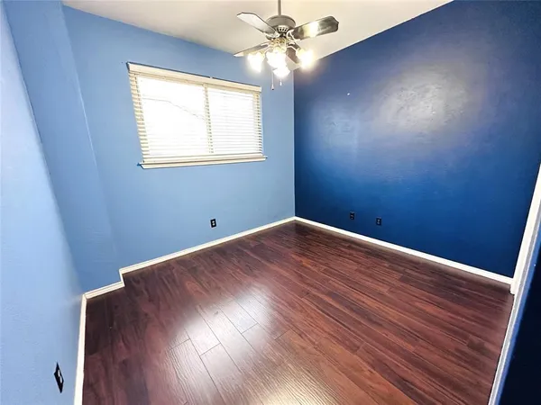 a view of a room with wooden floor and fan