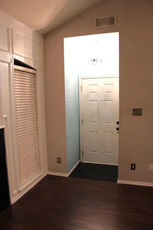 an empty room with wooden floor and window