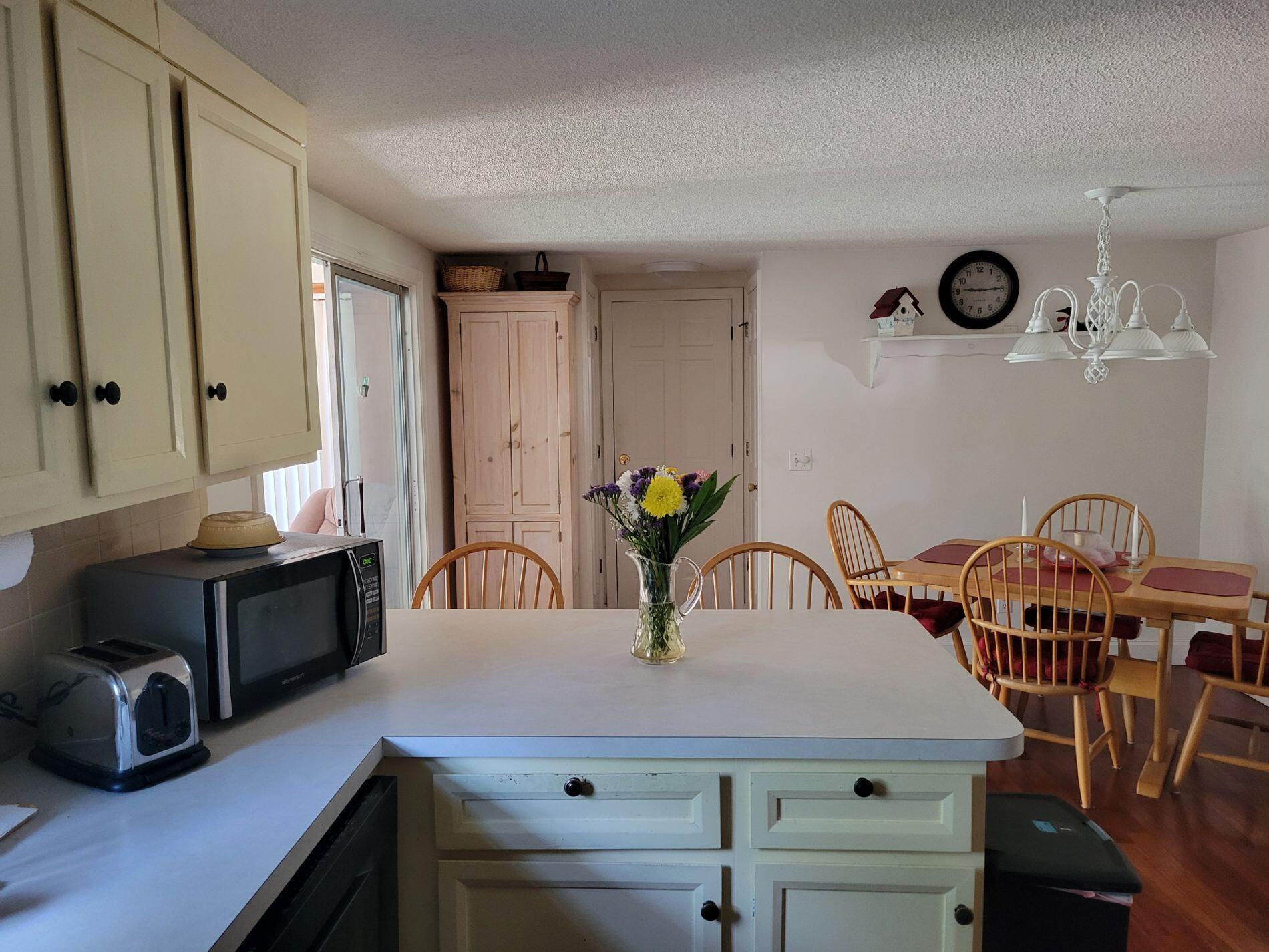 115 Captain Chase Road South Yarmouth, MA 02664 - Photo 12 of 36 a kitchen with stainless steel appliances kitchen island granite countertop a table chairs in it and wooden floors