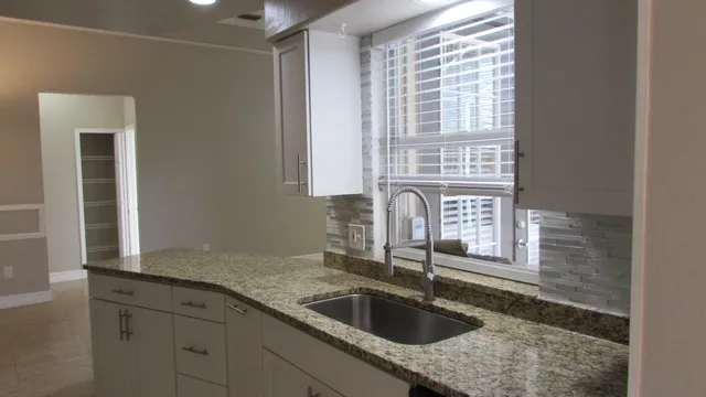 a kitchen with granite countertop a sink and a window