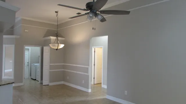 en empty room with a mirror and fan