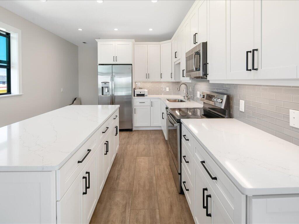 232 Harbor Place North Goodland, FL 34140 - Photo 12 of 24 a kitchen with white cabinets sink and stove