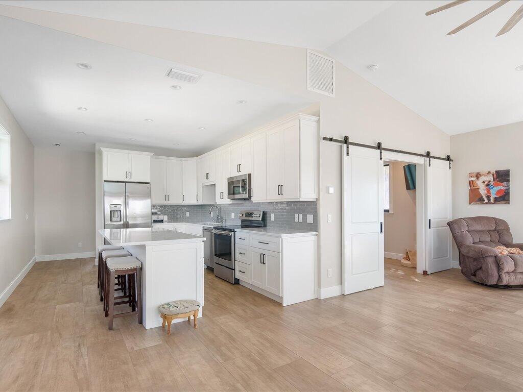 232 Harbor Place North Goodland, FL 34140 - Photo 9 of 24 a kitchen with white cabinets and white appliances