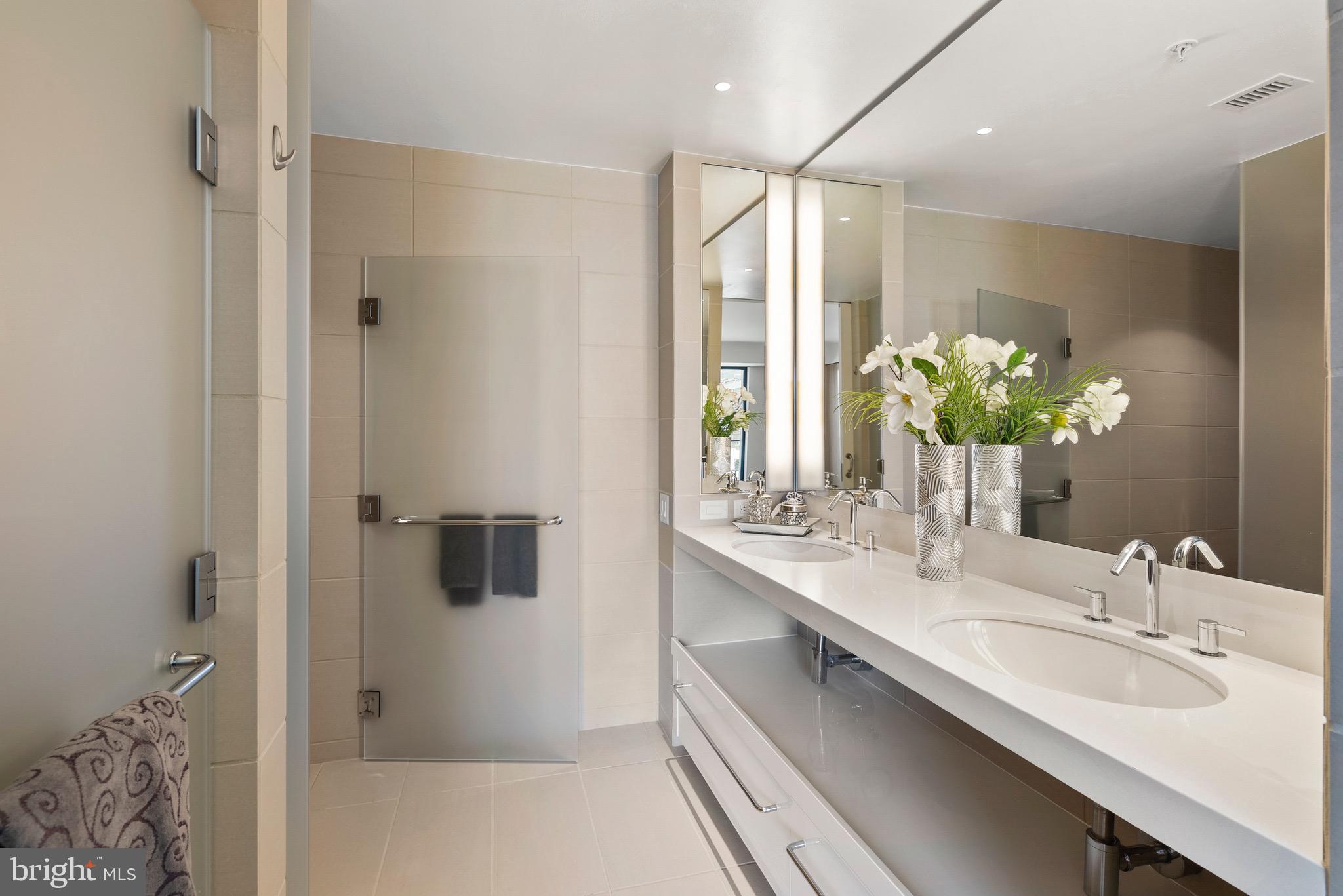 920 I Street Northwest, Unit 1009 Washington, DC 20001 - Photo 33 of 75 a bathroom with a sink double vanity granite tub shower and a mirror