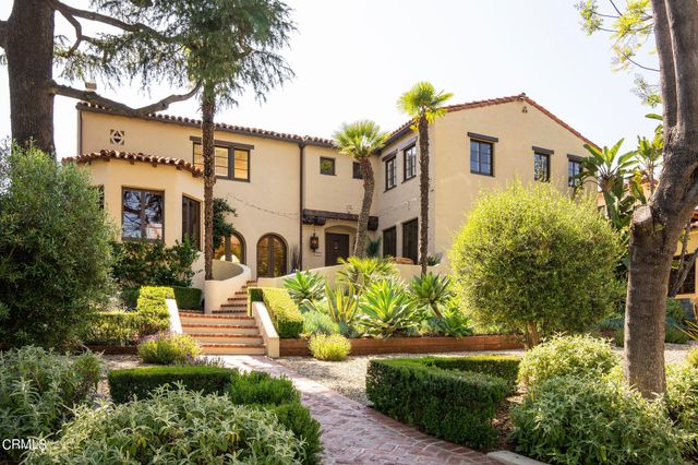 a front view of a house with a garden