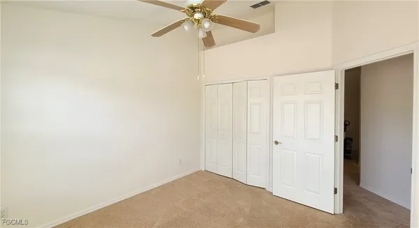 an empty room with a window and a fan