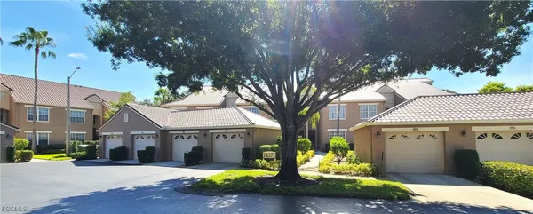 a front view of a house with a yard and potted plants