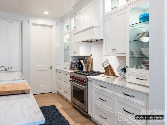 a kitchen with a stove and white cabinets