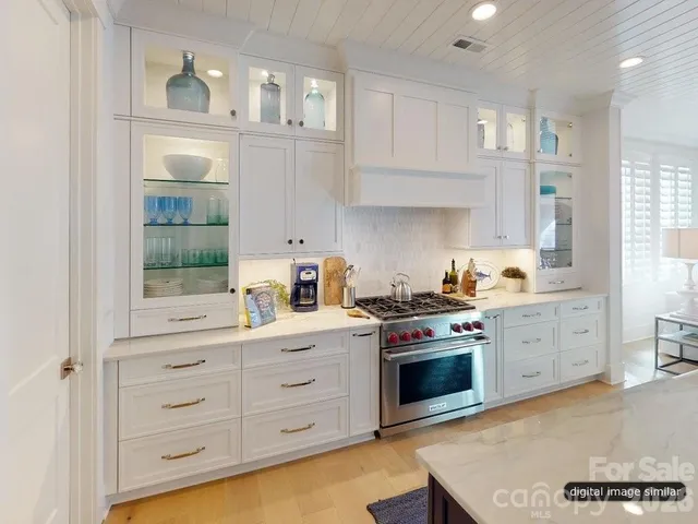 a kitchen with white cabinets and appliances