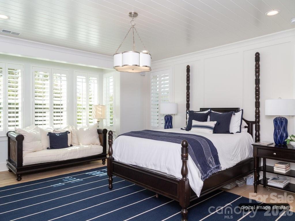 134 Willow Vw Loop, Unit 1 Davidson, NC 28036 - Photo 21 of 42 a spacious bedroom with a bed and a chandelier