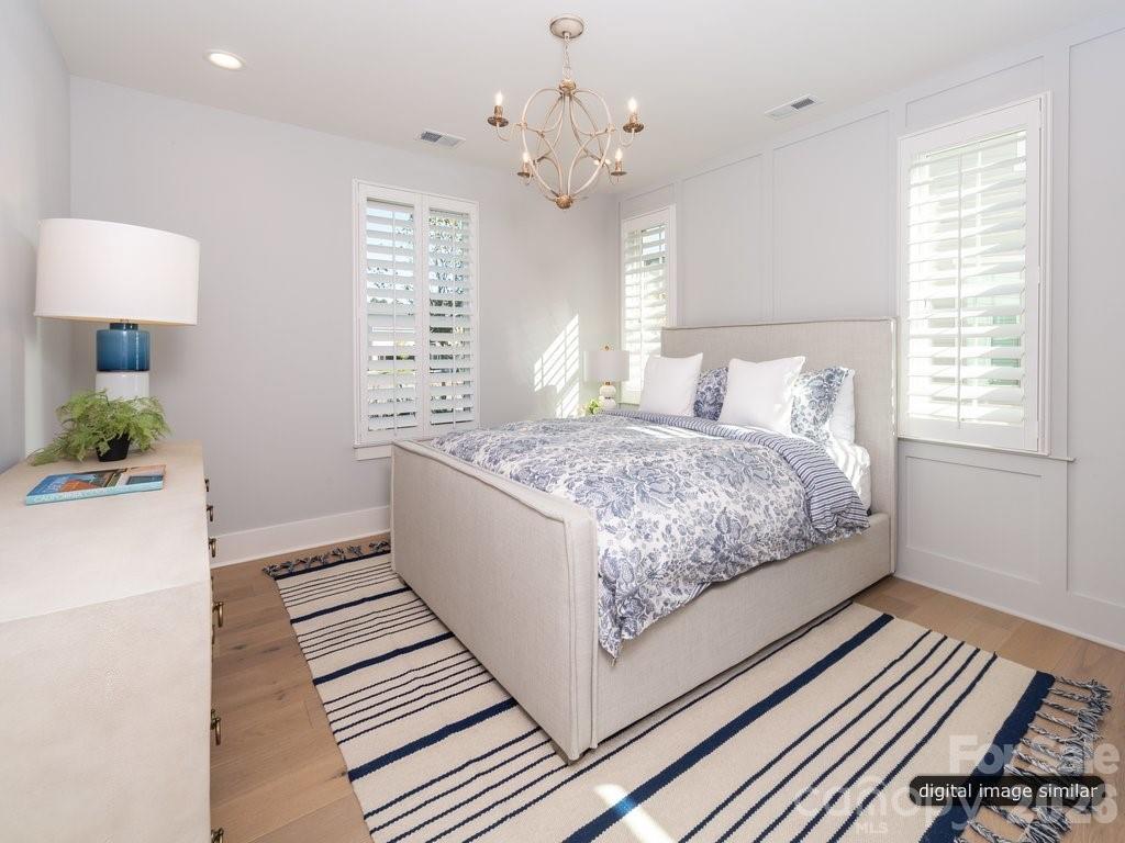134 Willow Vw Loop, Unit 1 Davidson, NC 28036 - Photo 24 of 42 a room with a bed and a chandelier