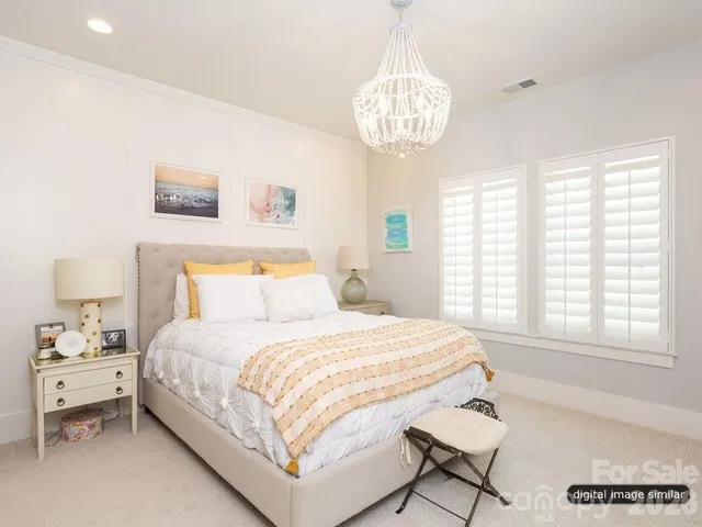 a bedroom with a large bed and a chandelier